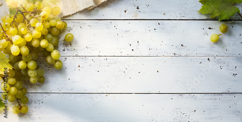 grapes on white table; seasoning vineyard background