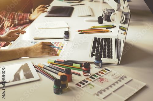 Zdjęcie XXL Młody projektant grafik komputerowych pracuje na nowożytnym komputerze stacjonarnym podczas gdy używać graficzną pastylkę przy biurkiem w biurze.