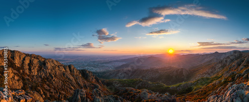 Beautiful sunset over the mountain hills and city, aerial panoramic view