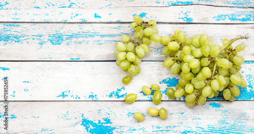 Bunch of fresh ripe green grapes on a old wooden table. Top view.