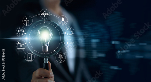 Man holding magnifying glass and light bulb ,searching global show the world's consumption with icons energy sources Ecology concept