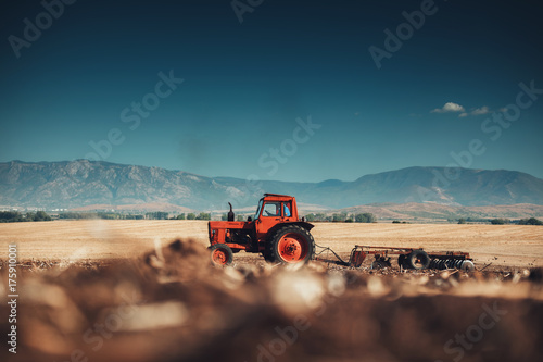 Farmer in tractor preparing land with seedbed cultivator
