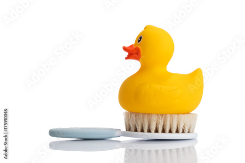 Rubber duck and hairbrush on a white background