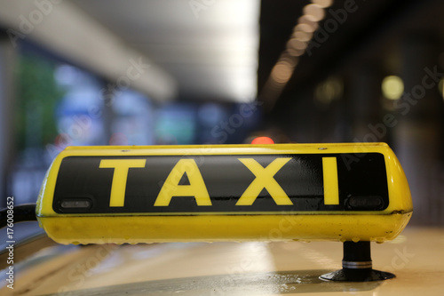 Fotoobraz na płótnie Taxi znak na samochodu dachu z odbiciem, wąż przy lotniskiem