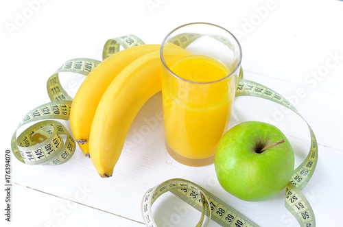Plakat Zdrowy łasowanie, dieting, odchudzanie i ważenie straty pojęcie, - zakończenie zielony jabłko, banan, pomarańcze, sok, pomiarowa taśma up.