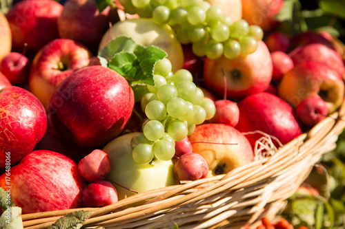 ripe apples with grapes in a basket