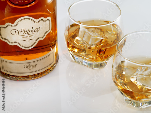 close up view of glasses with ice and whiskey and a bottle aside. self made label.