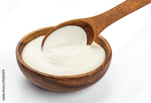 Sour cream in wooden spoon isolated on white background