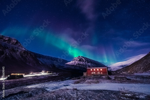 The polar arctic Northern lights aurora borealis sky star in Norway Svalbard in Longyearbyen the moon mountains