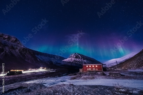 The polar arctic Northern lights aurora borealis sky star in Norway Svalbard in Longyearbyen the moon mountains
