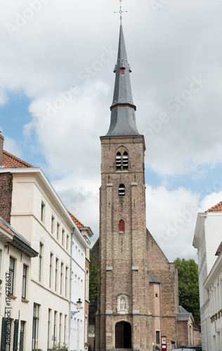 Sint Annakerk (St Anne's Church) at the end of the street in Bruges, Belgium. a 17th century church Baroque interior. Small local church surrounded by houses in Europe.
