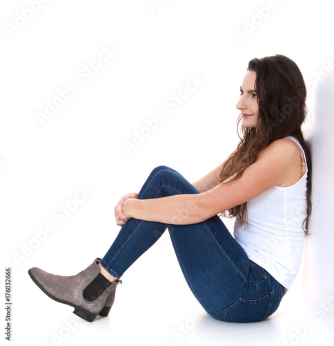 Junge Frau sitzt vor weißem Hintergrund