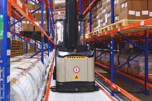 Zdjęcie XXL System przechowywania adresów produktów, materiałów i towarów w magazynie. Zarządzany wózek elektryczny między rzędami.