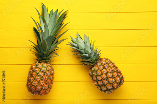 Ripe pineapples on yellow wooden table