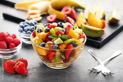Fruit salad in bowl on grey wooden table