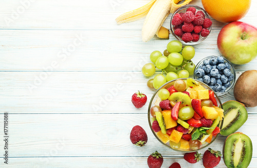 Fruit salad in bowl on white wooden table