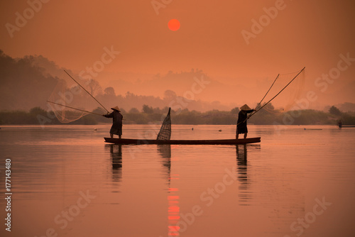 Plakat Dwa rybaka łowią na łodzi przy Mekong rzeką w ranku w Nong Khai, Tajlandia