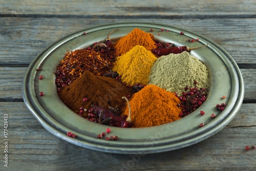Various type of spices in plate on wooden table