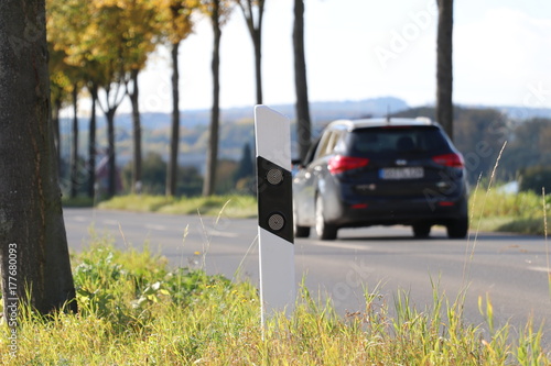 Landstraße mit Allee bei Göttingen mit Leitpfosten und Autoverkehr
