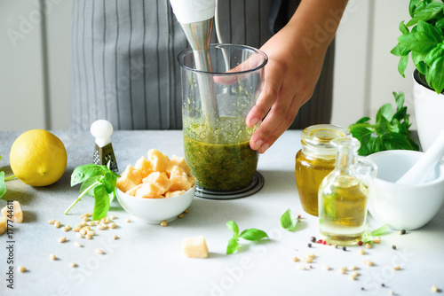 Fotoobraz na płótnie Kobieta używa ręka blender robić pesto. Biała kuchnia wnętrz. Skopiuj miejsce. Wegetariańskie, czyste pojęcie stylu życia