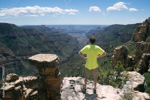 Plakat Nastolatek stoi na skraju skały i patrzy w dal. North Rim Park Narodowy Wielkiego Kanionu Arizona, USA