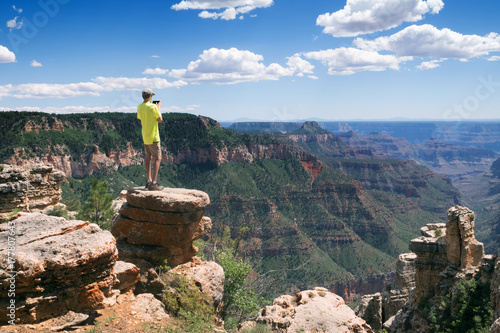 Plakat Nastolatek stoi na skraju urwiska i robi zdjęcia w krajobrazie telefonu. Arizona National Park, USA