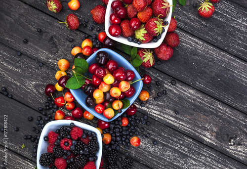 Fresh forest berries on wooden background. Top view