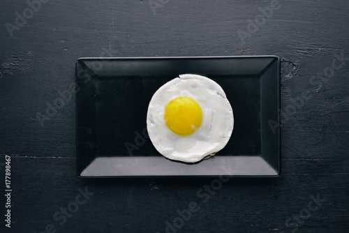 Plakat Smażony omlet. Na drewnianym tle. Widok z góry. Wolne miejsce na Twój tekst.