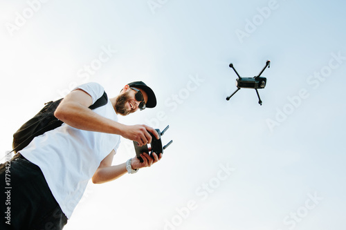 Man operating the drone by remote control and having fun