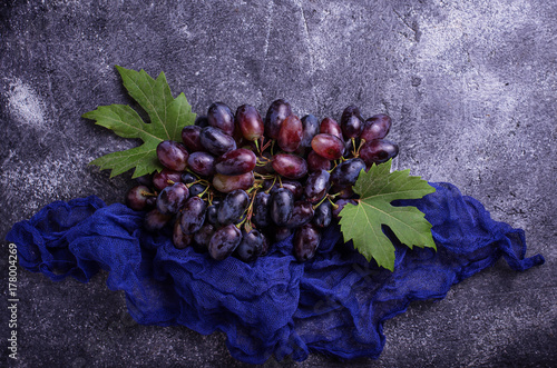 Bunch of purple grapes on concrete background