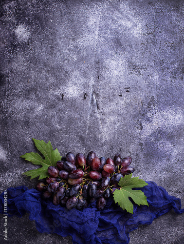 Bunch of purple grapes on concrete background