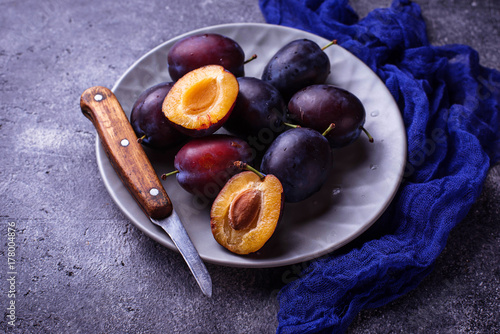 Fresh sweet plums on concrete background