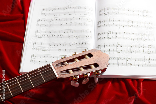 Plakat gitara akustyczna i nuty na czerwonym aksamicie tkaniny, Zamknij widok obiektów