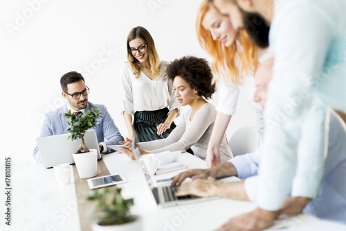 Group of businessmen and businesswomen working together in office.