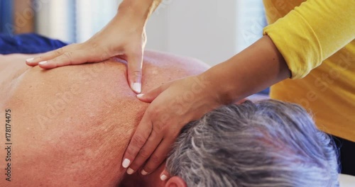 Physiotherapist giving shoulder massage to a senior man 