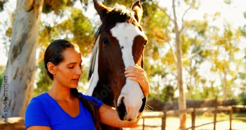 Woman grooming the horse in ranch 
