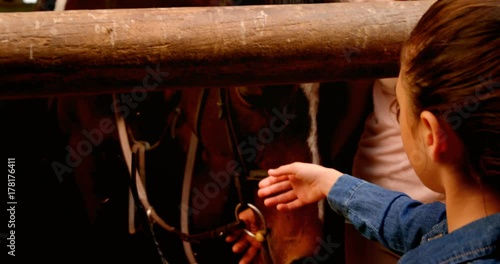 Mother and daughter stroking horse 