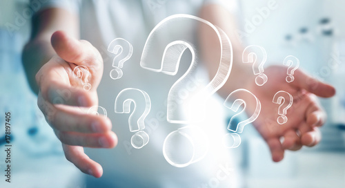Businessman holding hand drawn question marks
