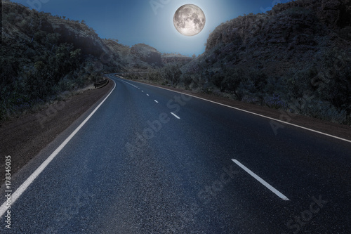 Full moon over the empty highway through the australian outback. Element of this image furnished by NASA