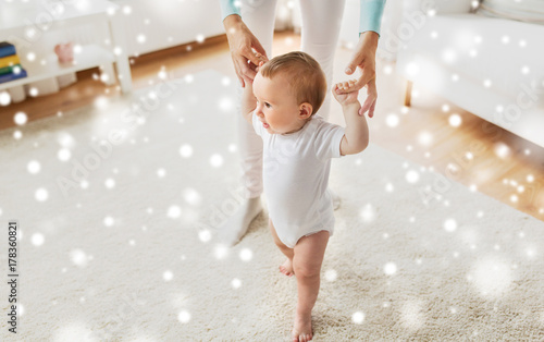 happy baby learning to walk with mother help