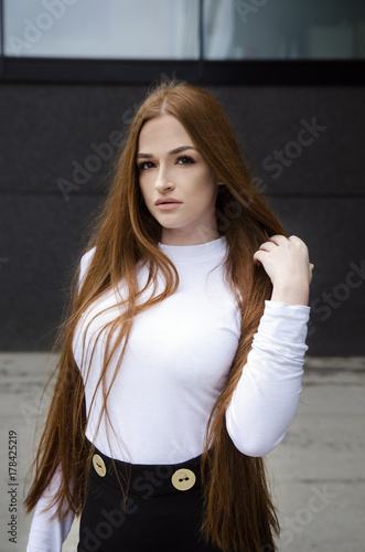 Plakat Młoda piękna atrakcyjna kobieta z długim czerwonym włosianym trwanie outside. Portret mody i urody.