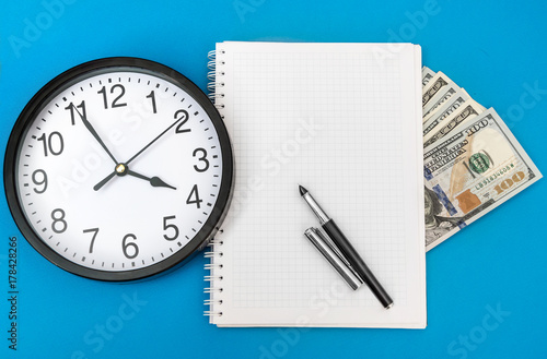 Blank notepad with money and clock. Business concept. Top view.