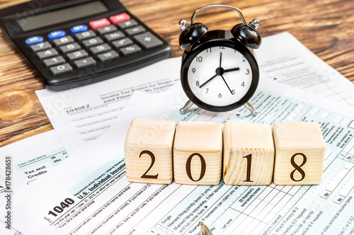 Wooden cubes with numbers "2018" with tax forms and calculator on the table. Business concept. Pay tax in 2018 year.
