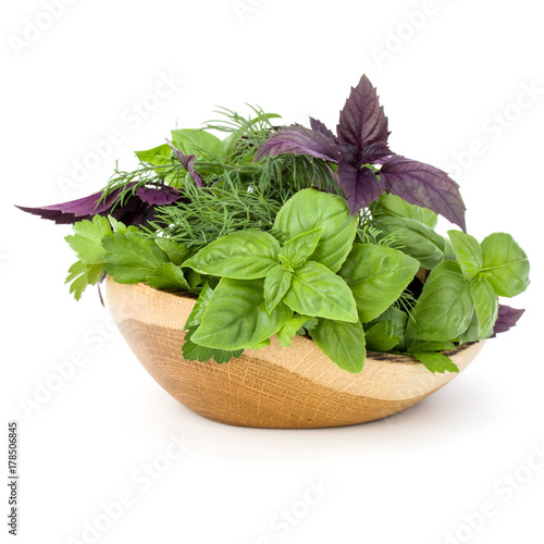 Fresh spices and herbs in wicker basket isolated on white background cutout. Sweet basil, red basil leaves, dill and parsley.