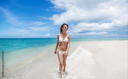 Sexy bikini body woman playful on paradise tropical beach having fun playing splashing water in freedom. Beautiful fit body girl on travel vacation