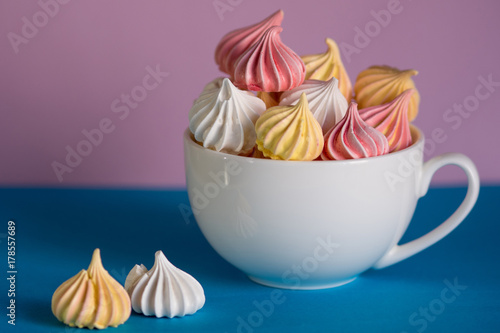 Dessert with meringue, a lot of colorful meringues in the tea Cup