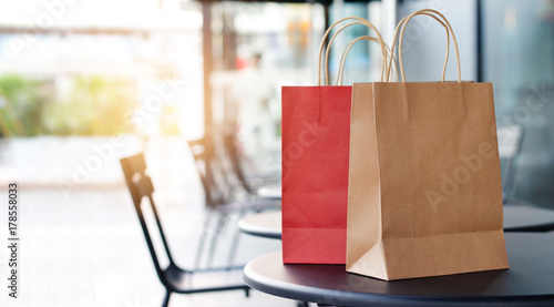 Red and brown shopping bags on tables at front mall store background, business, retail, banner concept