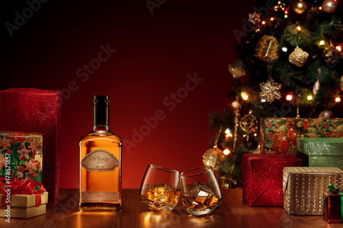 view  of bottle and two glasses with whiskey on color back. self made label.