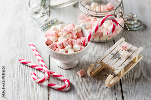Fotoobraz na płótnie Świąteczna filiżanka z małymi marshmallows i cukierków trzcinami