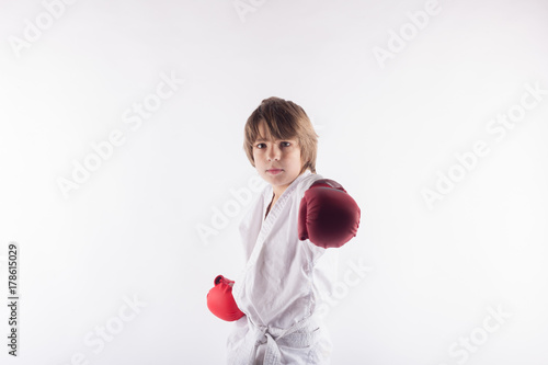 Fotoobraz na płótnie Portret jest ubranym kimonowe, czerwone bokserskie rękawiczki i pozować karate dzieciak